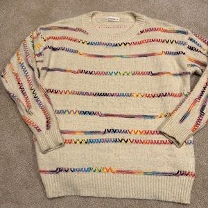 Fun cream sweater with rainbow stitching